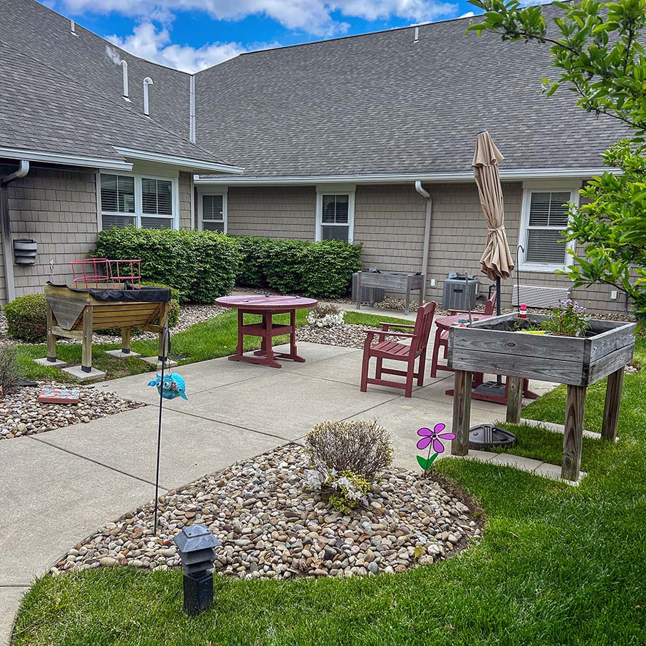 A sitting area outdoors at Hudson Grande with landscaping and foliage.